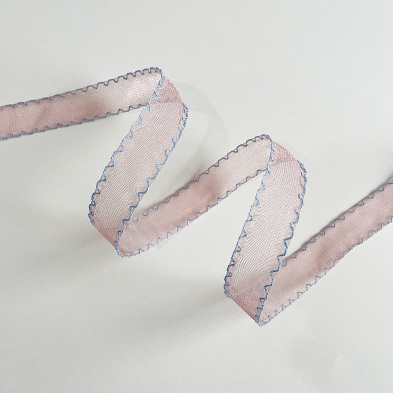 Scallop edge sheer ribbon rolls in pink sage blue and floral print arranged on antique plate with grape hyacinth and ranunculus — Sivonna bridal craft ribbon collection
