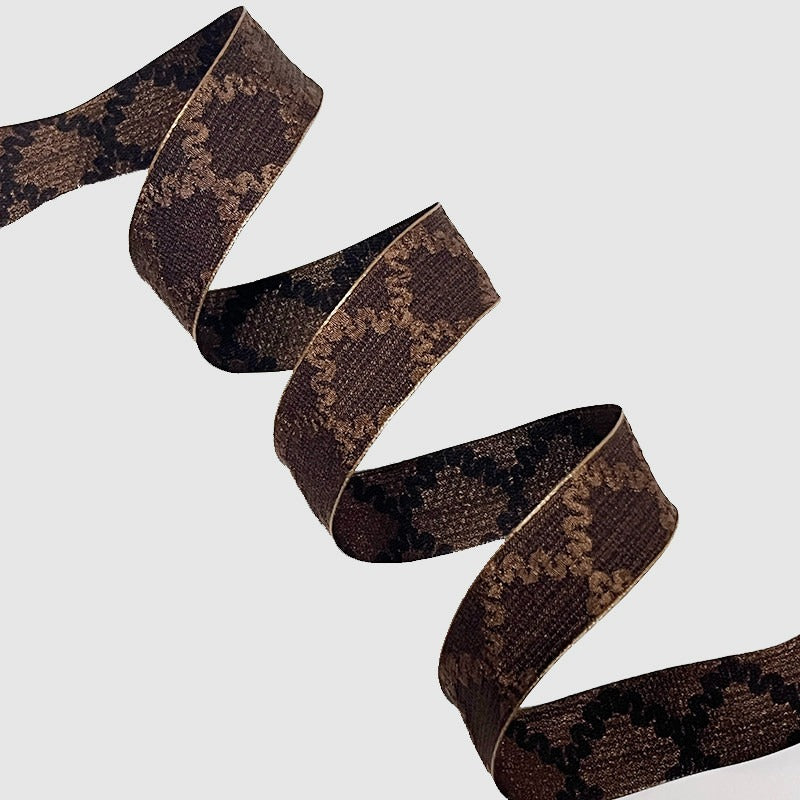 Chocolate brown wired ribbon in sharp zigzag fold showing deep dark matte surface — Sivonna decorative wreath ribbon