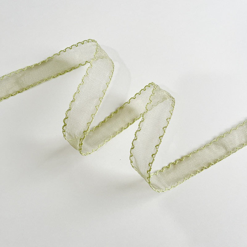 Sage green scallop edge sheer ribbon folded in zigzag showing muted green organza with contrast scallop stitch — Sivonna garden party ribbon