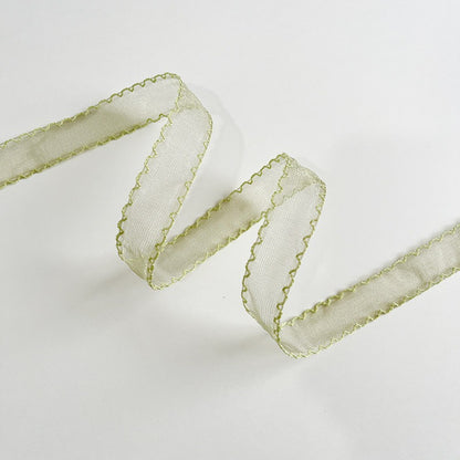Sage green scallop edge sheer ribbon folded in zigzag showing muted green organza with contrast scallop stitch — Sivonna garden party ribbon