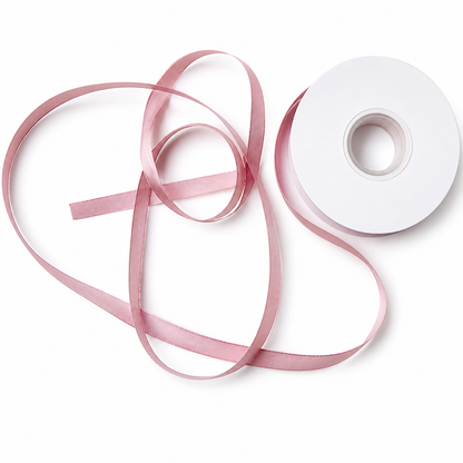 Pink sheer and satin ribbons crossed and layered over white spool showing tonal coordination across textures — Sivonna bridal bow making ribbon